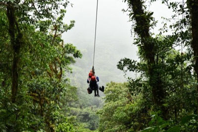 Riding a zipline across the rainforest canopy